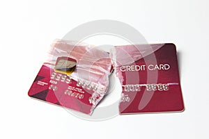 Closeup of the broken red credit card on the white background.