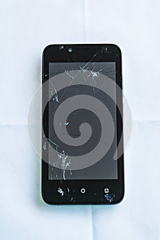 Closeup of broken smartphone, cracked glass in play by children.
