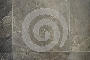 Closeup of a brown tile flooring with a marble texture