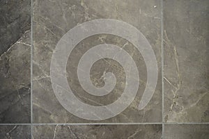 Closeup of a brown tile flooring with a marble texture