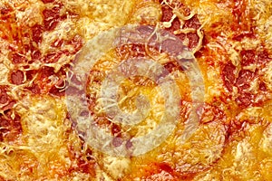 Closeup of browned cheese crust covering soy sausage slices on vegan pizza