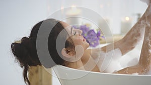 Closeup brunette woman washing hands with foam. Elegant girl relaxing in bath