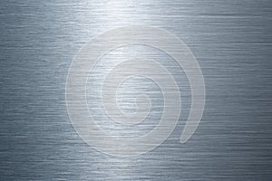 Closeup of brushed metal surface with horizontal grain and light reflection
