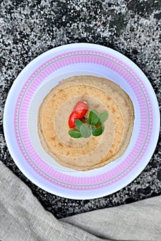 closeup the bunch brown color frayed tortilla with red chilly , green mint in the plastic plate with grey cloth soft focus natural