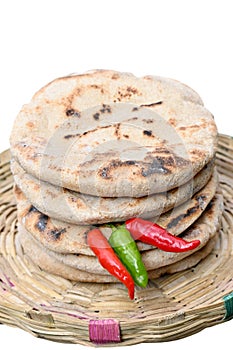 closeup the bunch brown color tortilla with red green chilly in the grey brown bucket on the white background