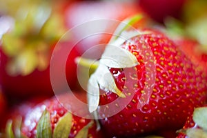 Closeup of a bunch of fresh large ripe strawberries on the kitchen table before cooking, selective focus