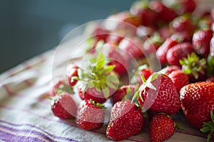 Closeup of a bunch of fresh large ripe strawberries on the kitchen table before cooking, selective focus