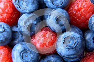 Closeup of a bunch of raspberries and blueberries