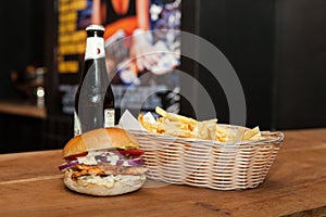 Closeup of a burger with French fries and beer on a table
