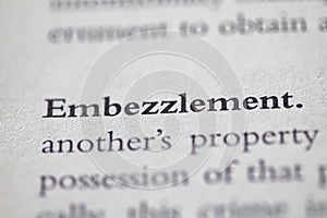 Closeup of Business legal term Embezzlement printed in textbook on white page. photo