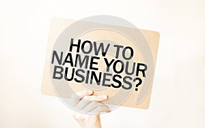 Closeup Business man hand holding show blank paper sheet HOW TO NAME YOUR BUISINESS photo