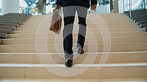 Closeup of business man leg go up the stairs. Traveling. Back view. Exultant.