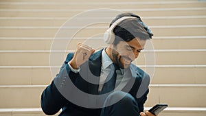 Closeup of business man listen and enjoy music while wear headphone. Exultant.