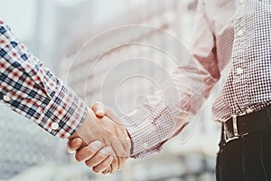 Closeup of a business man with luggage travel hand shake between two colleagues greet