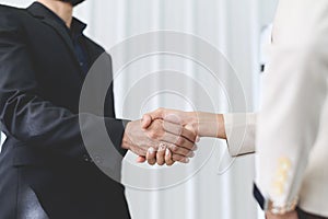 closeup of business partners shaking hands after concluding a business finished. Businessman and Businesswoman handshake in the