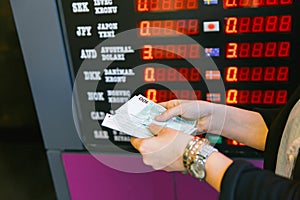 Closeup of business woman with counting money. Woman hands counting euro banknotes against the background of a currency exchange