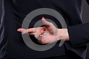 Closeup of business woman with crossed fingers