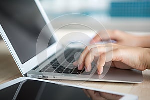 Closeup of business woman hand typing on laptop keyboard