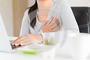 Closeup business woman having heart attack. Woman touching breast and having chest pain after long hours work on computer. Office