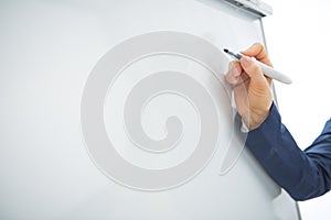 Closeup on business woman writing on flipchart