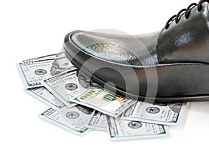 Closeup of businessman black leather shoe stepping on pile of money