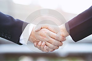 Closeup of a businessman hand shake businesswoman between two colleagues