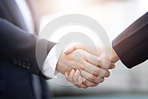 Closeup of a businessman hand shake businesswoman between two colleagues