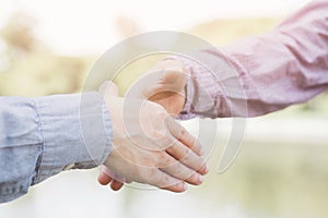 Closeup of a businessman hand shake businesswoman between two colleagues OK, succeed