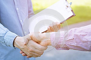 Closeup of a businessman hand shake businesswoman between two colleagues OK, succeed
