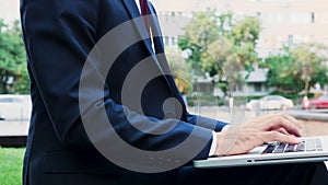 Closeup of businessman hand typing management strategy on laptop computer keyboard