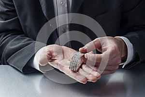 Closeup on businessman hands displaying precious metal jewel for concept of gold and money in hands photo