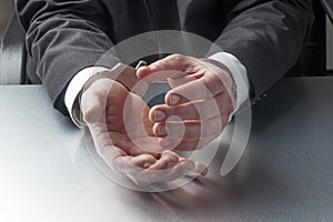 Closeup on businessman hands with handcuffs on for concept of crime or justice at work