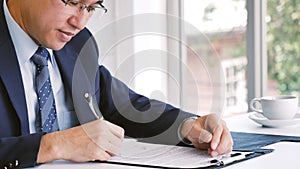 Closeup businessman hands working use laptop finance business document reading report paperwork spreadsheet at office desk. Man