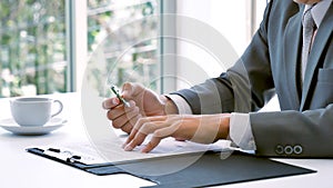Closeup businessman hands working use laptop finance business document reading report paperwork spreadsheet at office desk. Man