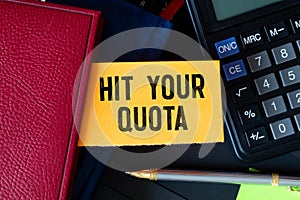 Closeup on businessman holding a card with text HIT YOUR QUOTA, business concept photo