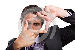Closeup of a businessman looking through finger frame