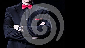 Closeup of businessman in luxury suit with crossed arms. Over black background. No face.