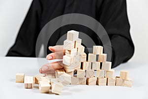 Closeup of businessman making a pyramid with empty wooden cubes