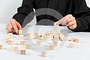 Closeup of businessman making a pyramid with empty wooden cubes