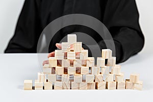 Closeup of businessman making a pyramid with empty wooden cubes