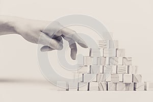 Closeup of businessman making a pyramid with empty wooden cubes