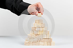 Closeup of businessman making a pyramid with empty wooden cubes