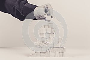 Closeup of businessman making a pyramid with empty wooden cubes