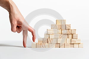 Closeup of businessman making a pyramid with empty wooden cubes