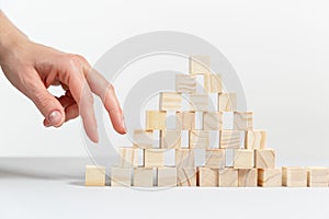 Closeup of businessman making a pyramid with empty wooden cubes