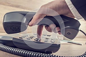 Closeup of businessman making a telephone call by dialing a phon