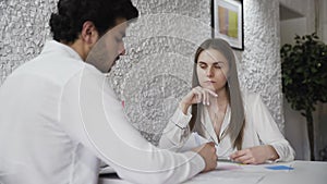 Closeup of businessman showing his new business partner where to sign an rental agreement or contract with fountain pen