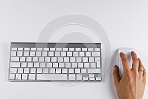 Closeup of businesswoman hand using wireless computer mouse and keyboard