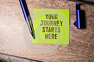 Closeup businesswoman hands holding white card sign with Your Journey Starts Here text