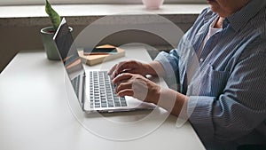 Closeup businesswoman hands typing laptop keyboard in open space. Serious manager messaging with client at workplace